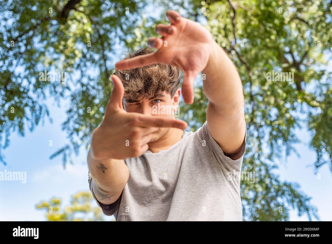 Ein Mann, der ein Foto über den Naturhintergrund einrahmt Stockfoto