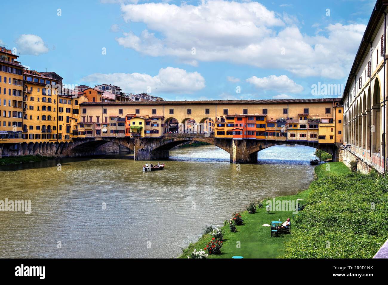 Florenz, Italien, 10. Mai 2018: Die Ponte Vecchio, die mittelalterliche steinerne Brücke über den Fluss Arno, die noch Geschäfte entlang gebaut, mit dem Fluss b Stockfoto
