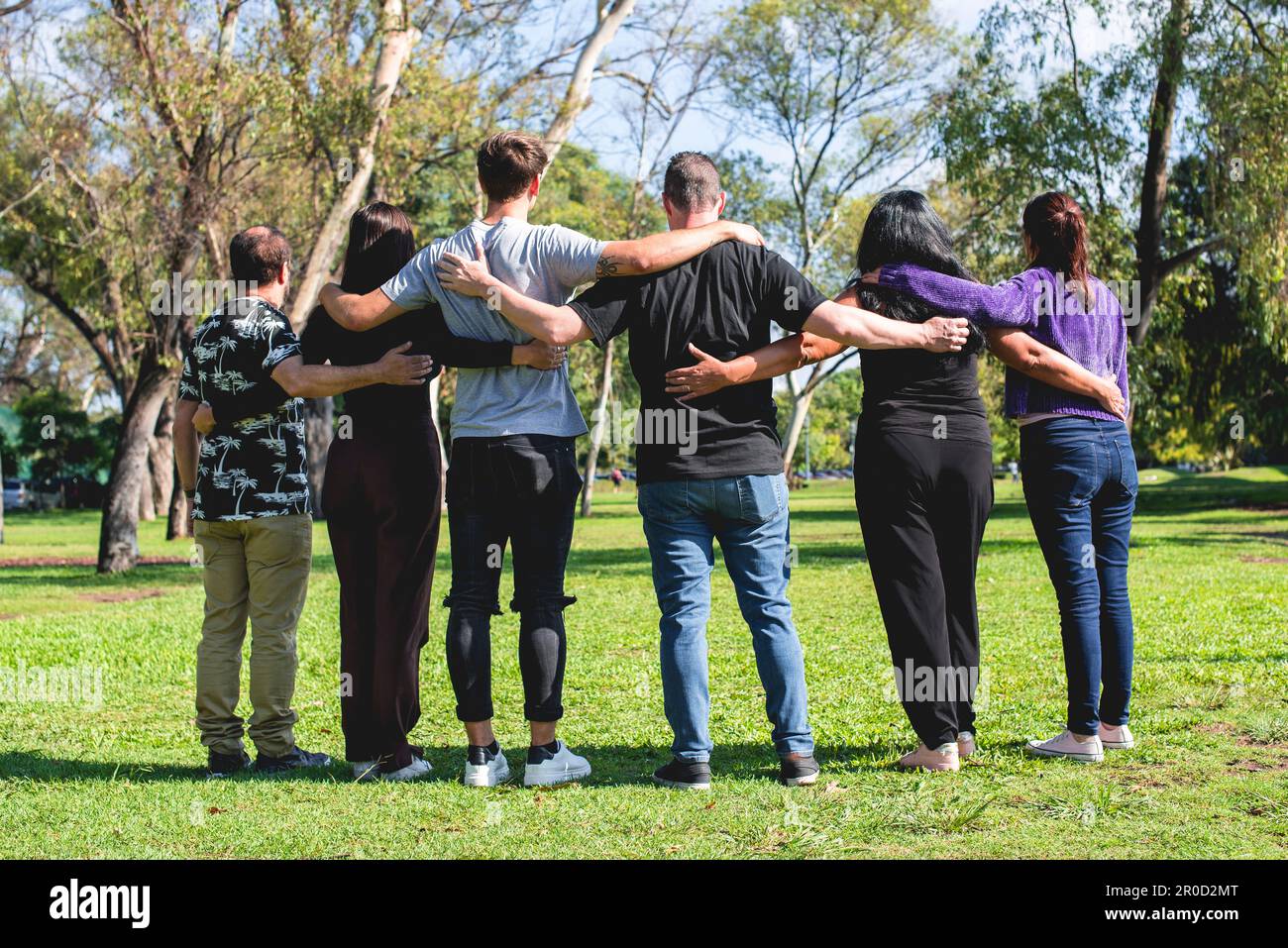 Rückansicht einer Gruppe umarmter Freunde. Freundschafts- und Supportkonzept. Stockfoto