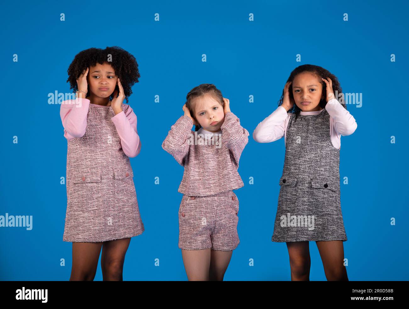 Unglücklich beleidigte internationale kleine Mädchen in lässigen Ohren, leiden unter Lärm Stockfoto