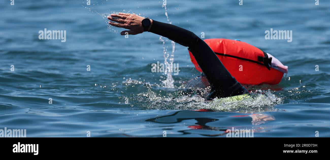 Langstreckenschwimmer-Marathonschwimmer in Aktion. Schwimmender Mann in sauberem Meerwasser. Schwimmen im offenen Wasser Stockfoto