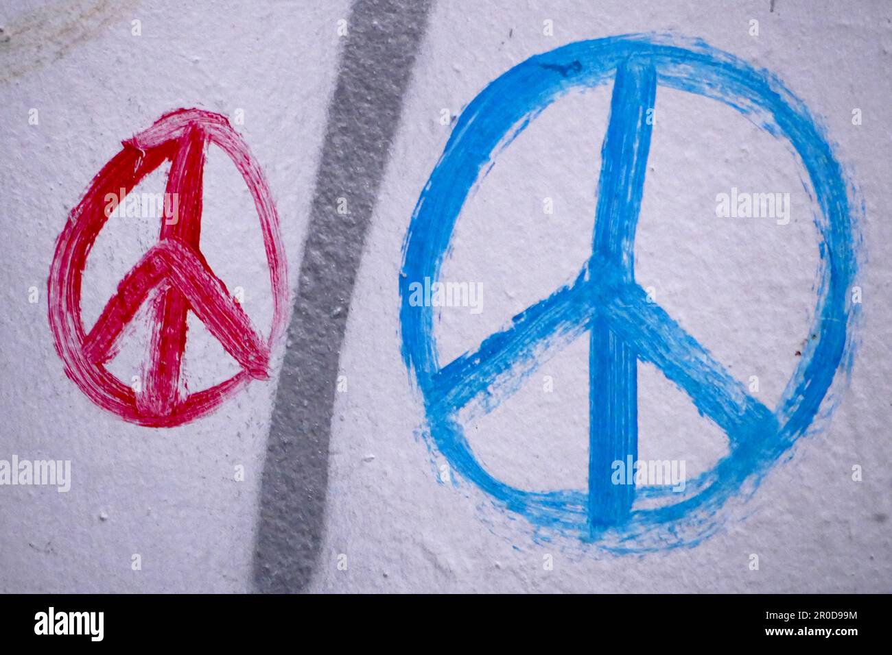 Rote und blaue Friedenssymbole an einer Wand Stockfoto