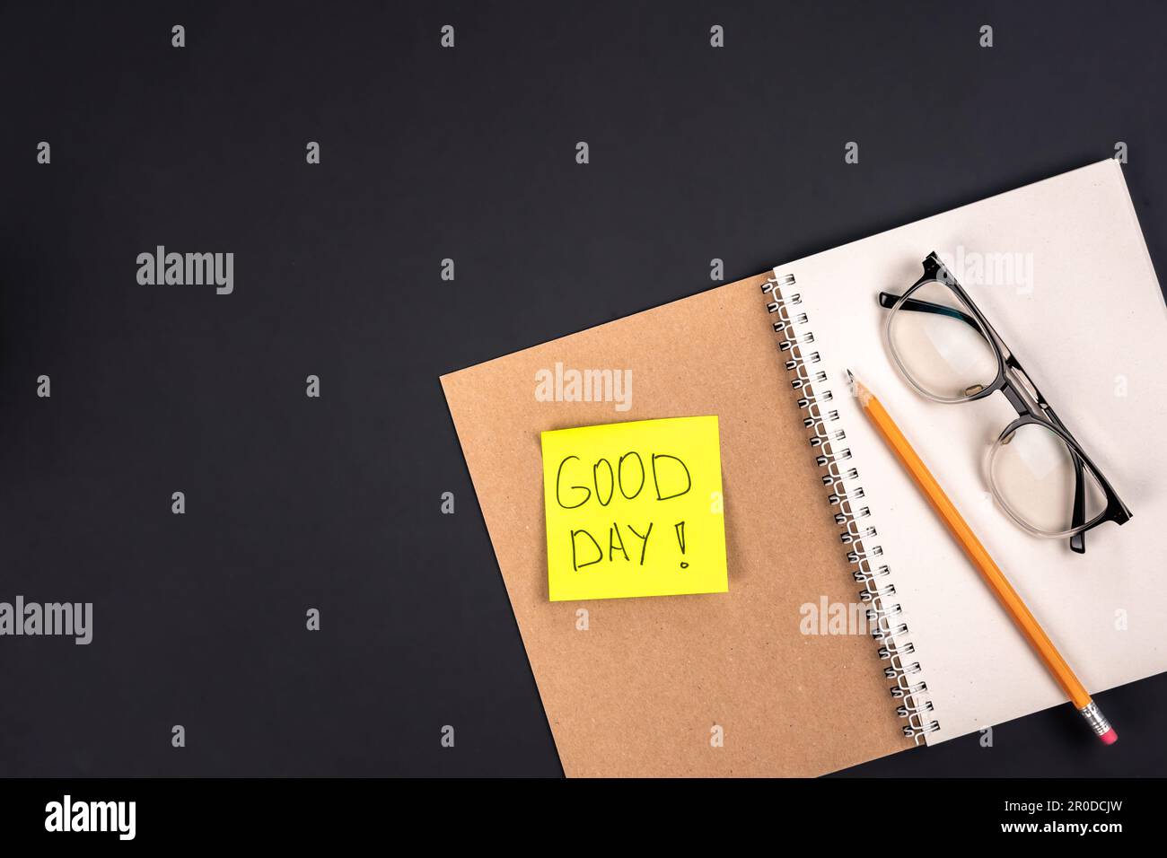 Öffnen Sie Notizblock, Brille, Bleistift und Papieraufkleber mit der Inschrift Good Day. Stockfoto