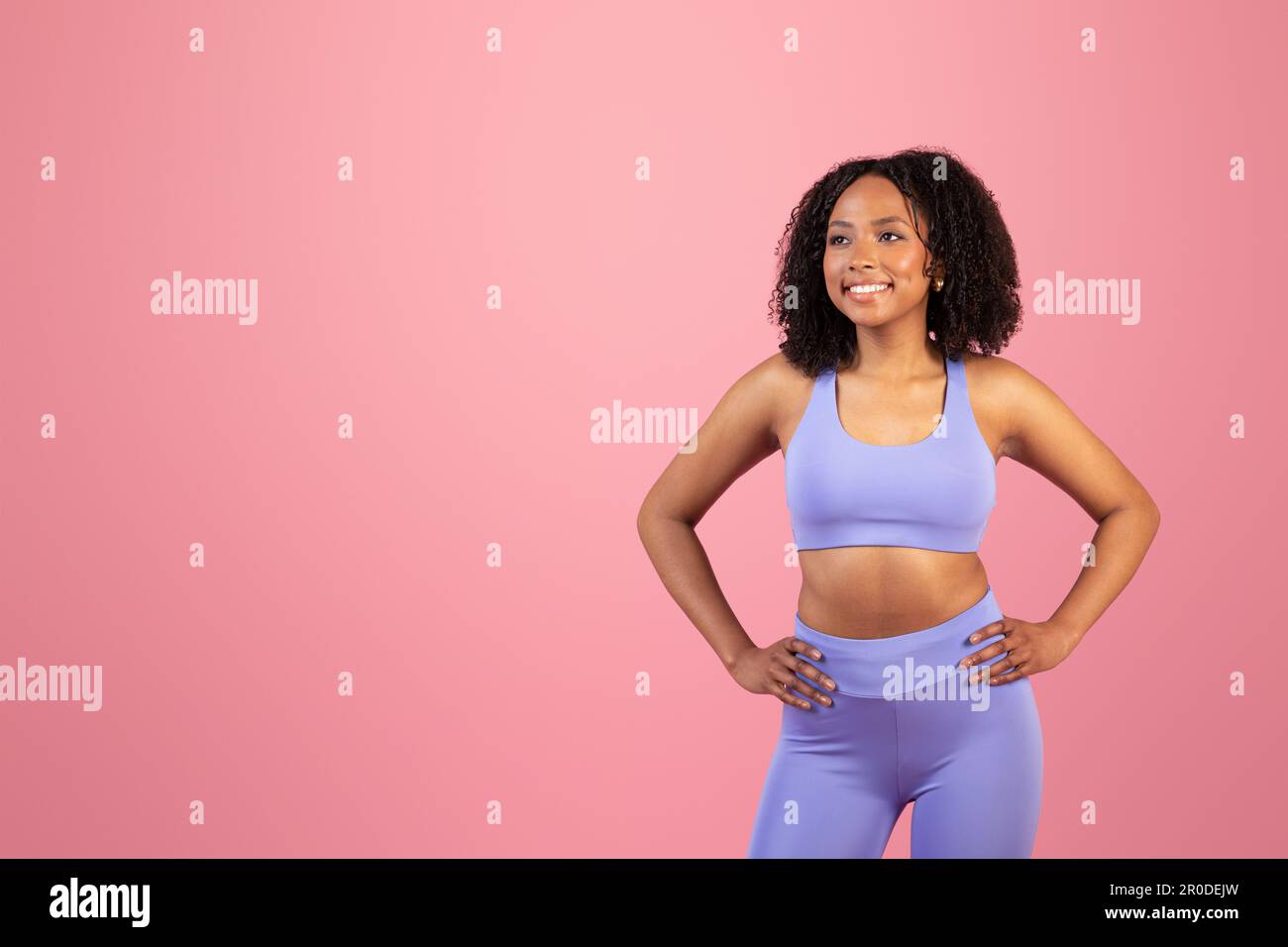 Positive Millennials-afroamerikanerin in Violet-Sportbekleidung, schauen sich freien Platz an Stockfoto