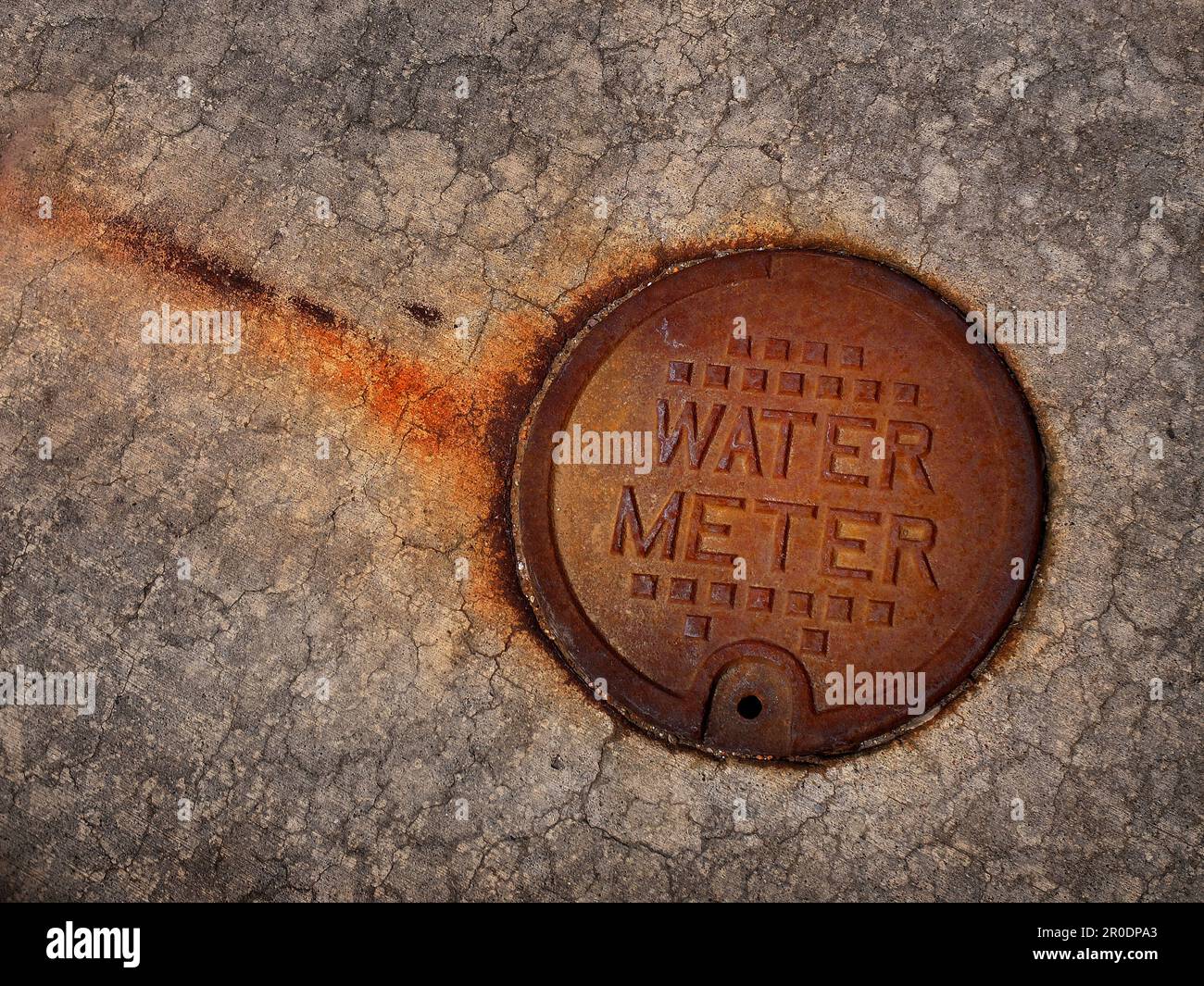 Detaildarstellung der Oberfläche der verwitterten, verrosteten Wassermessgeräteabdeckung Stockfoto