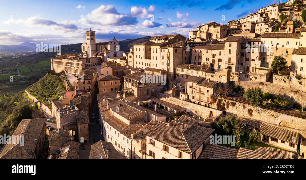 Beeindruckende mittelalterliche Stadt Assisi in Umbrien bei Sonnenuntergang. Italien. Panoramablick von der Drohne aus der Luft. italienische Reiseziele und beste Reiseziele Stockfoto