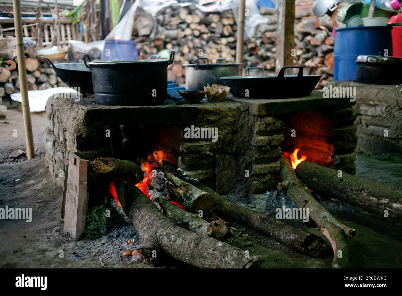 Ländliche Küche. Traditionelle Öfen, die von den Bewohnern im ländlichen Indonesien verwendet werden, aus Ton, mit Holz angetrieben, Kochen von Speisen auf Erdofen mit trockenen Blättern und Stockfoto