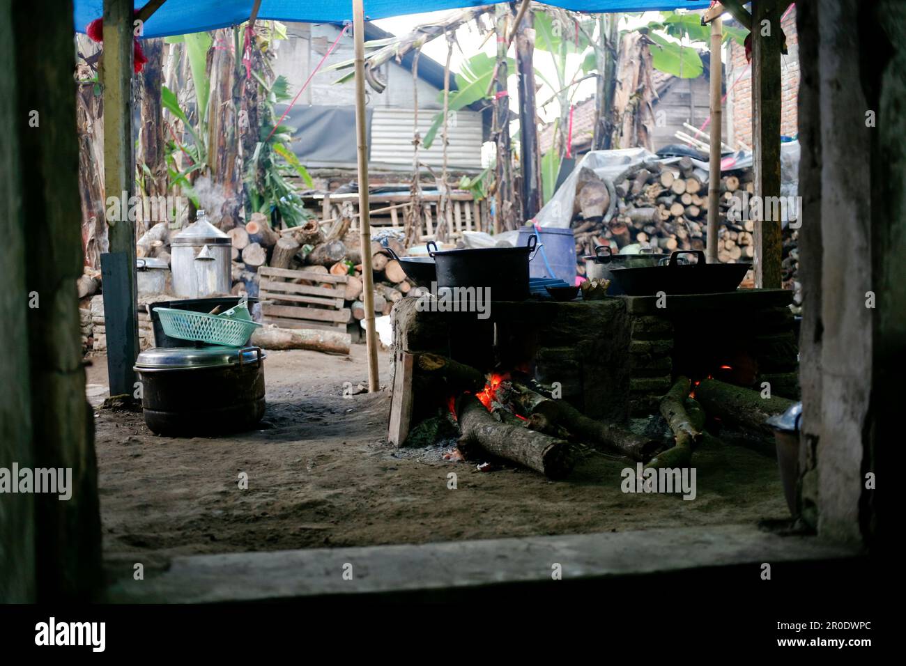 Ländliche Küche. Traditionelle Öfen, die von den Bewohnern im ländlichen Indonesien verwendet werden, aus Ton, mit Holz angetrieben, Kochen von Speisen auf Erdofen mit trockenen Blättern und Stockfoto