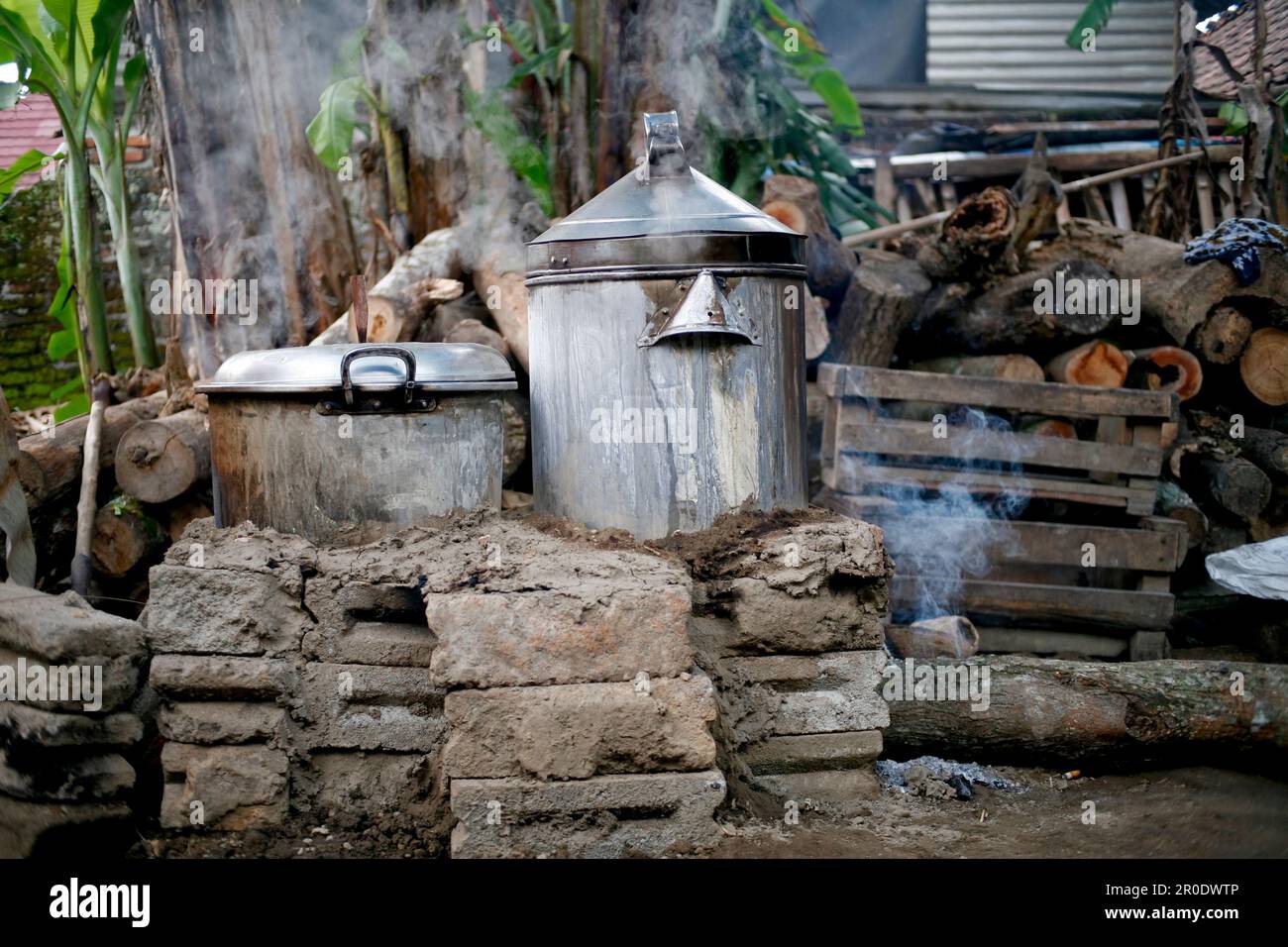 Ländliche Küche. Traditionelle Öfen, die von den Bewohnern im ländlichen Indonesien verwendet werden, aus Ton, mit Holz angetrieben, Kochen von Speisen auf Erdofen mit trockenen Blättern und Stockfoto