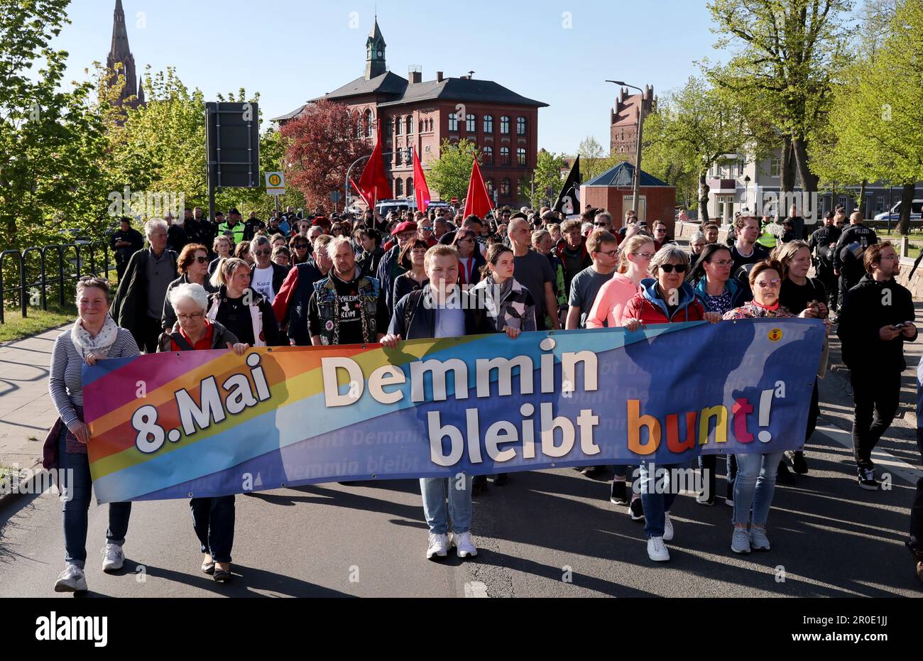 Demmin, Deutschland. 08. Mai 2023. Eine Demonstration gegen einen npd-marsch bewegt sich durch das Stadtzentrum, ein Banner mit der Aufschrift „Demmin bleibt bunt! Mai 8!“. Der Grund für den abendlichen marsch der Rechtsextremisten ist ein Massenselbstmord in der Stadt während der Invasion der Roten Armee zwischen 30,04. Und 03.05.1945. Kredit: Bernd Wüstneck/dpa/Alamy Live News Stockfoto