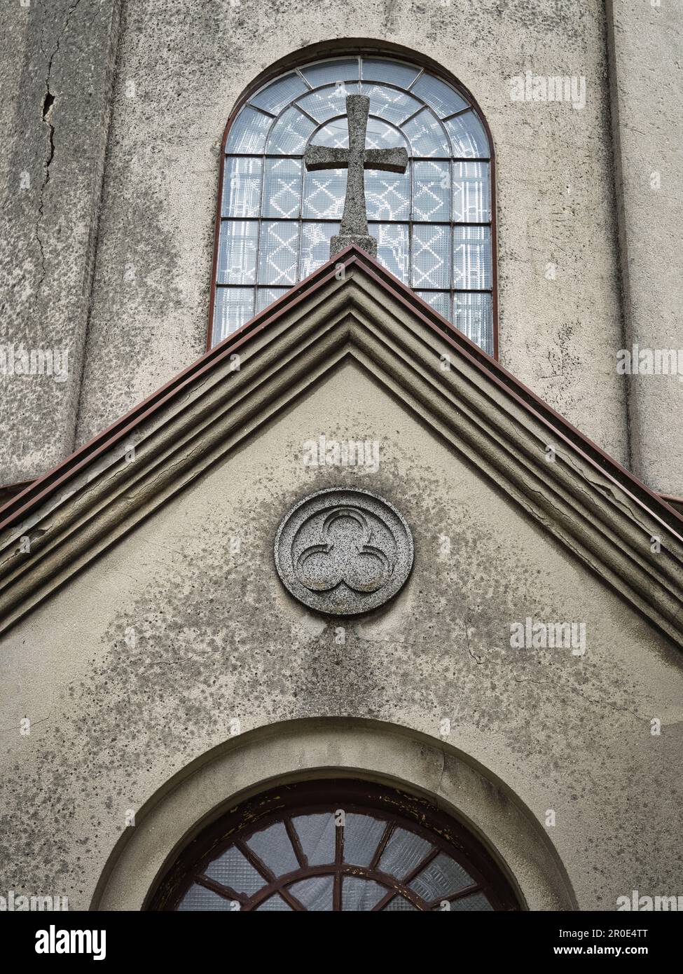 Das Symbol der Heiligen Dreifaltigkeit an der Fassade der Kirche über dem Eingang Stockfoto