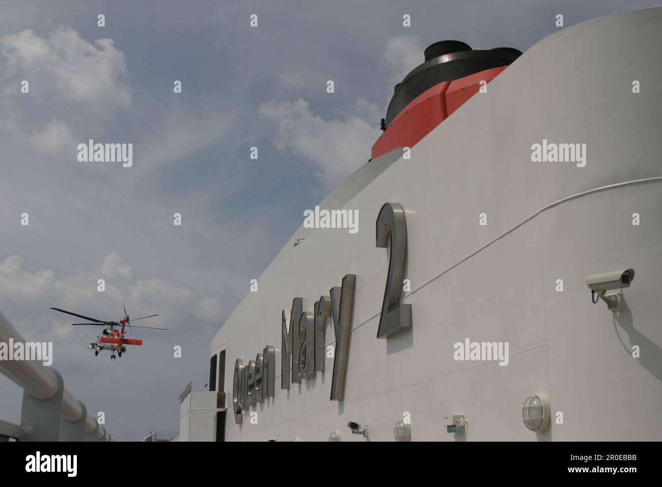 Königin Mary 2, Bergung, Hubschrauber der US-Küstenwache, Königin Mary 2, QM2 ein Hubschrauber der US-Küstenwache bei der Bergung eines verletzten Besatzungsmitgl Stockfoto