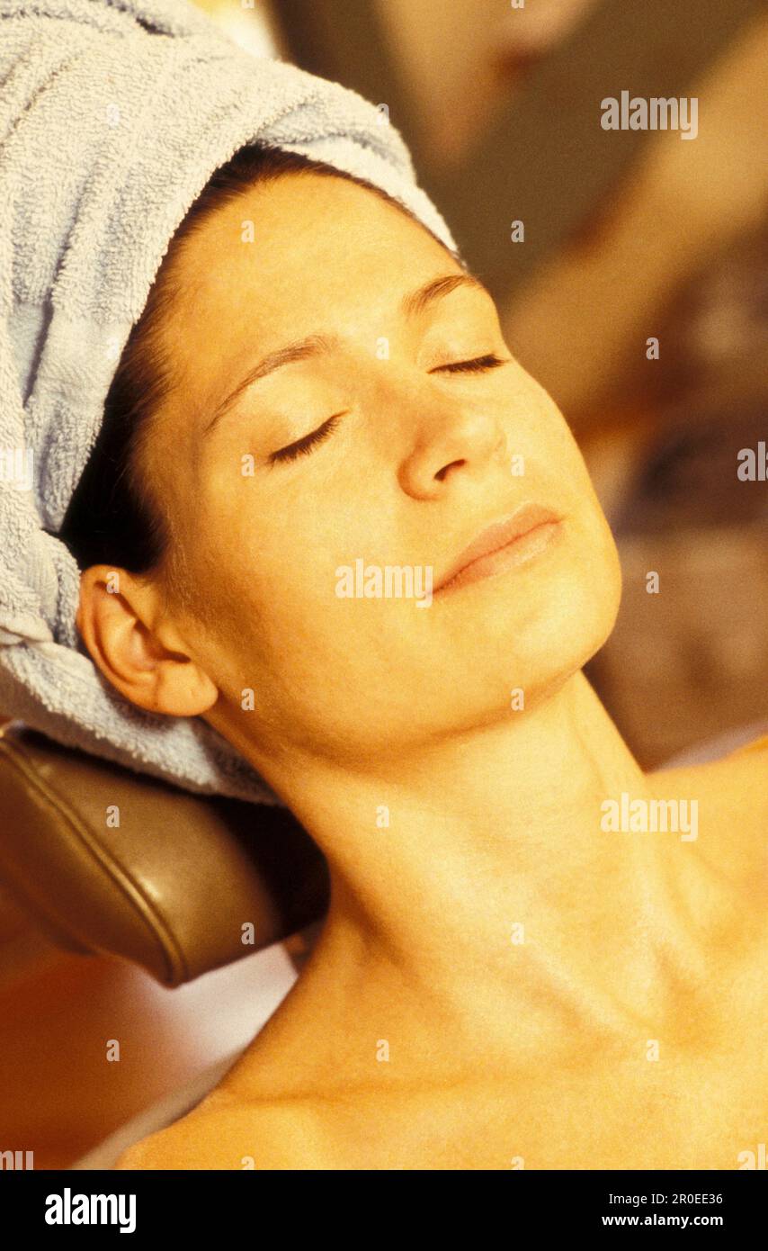Frau mit Handtuch am Kopf entspannt, Wien, Österreich Stockfoto