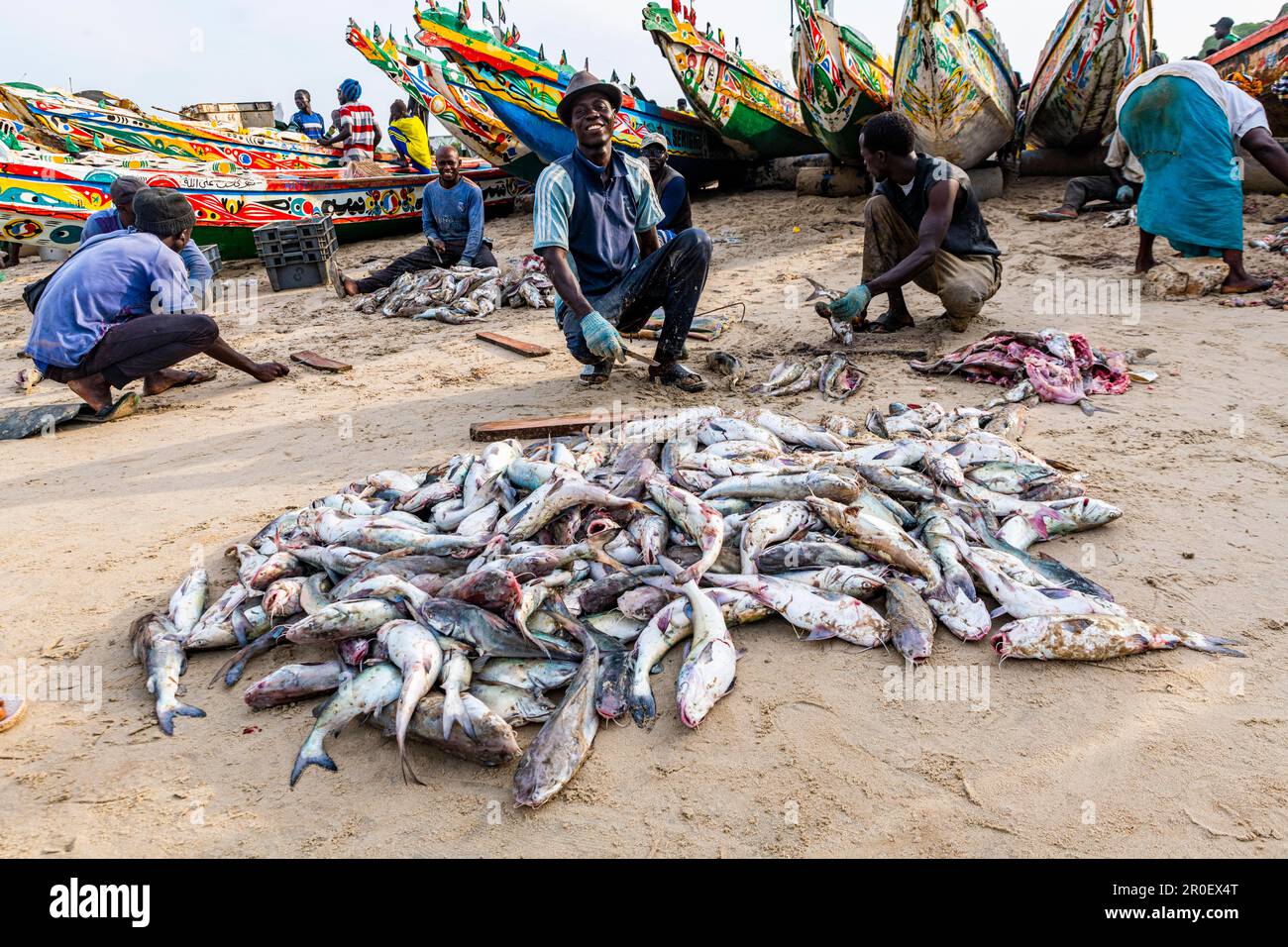 Fischer vor den bunten Fischerbooten, Cap Skirring, Casamance, Senegal Stockfoto