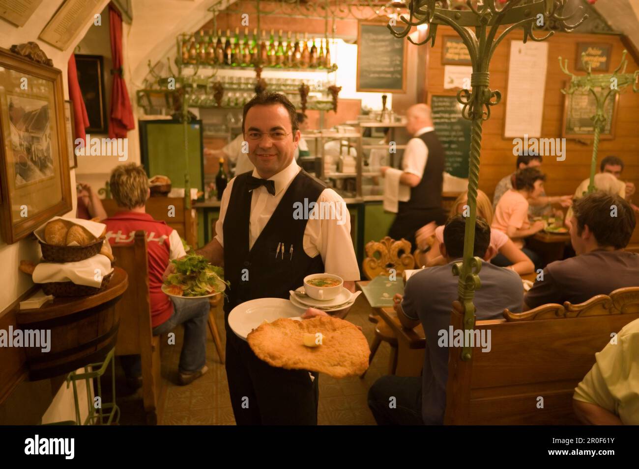 Der Kellner serviert Wiener Schnitzel im Restaurant Figlmueller, Wien, Österreich Stockfoto