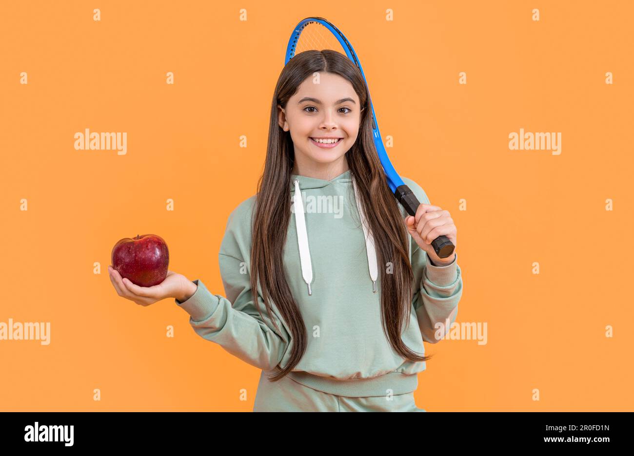 Teenager-Tennismädchen im Studio. Teenager-Tennis-Mädchen im Hintergrund. Foto von Teenager Tennis Girl mit Apfel. Stockfoto
