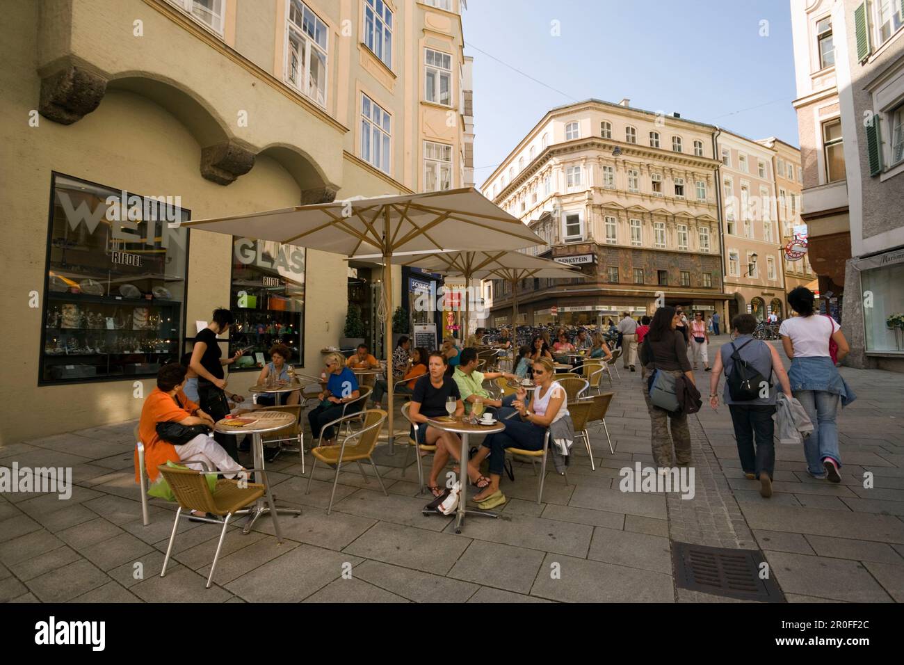 Frauen passieren ein Straßencafé in Salzburg, Salzburg, Österreich, seit 1996 historisches Zentrum der Stadt Teil des UNESCO-Weltkulturerbes Stockfoto