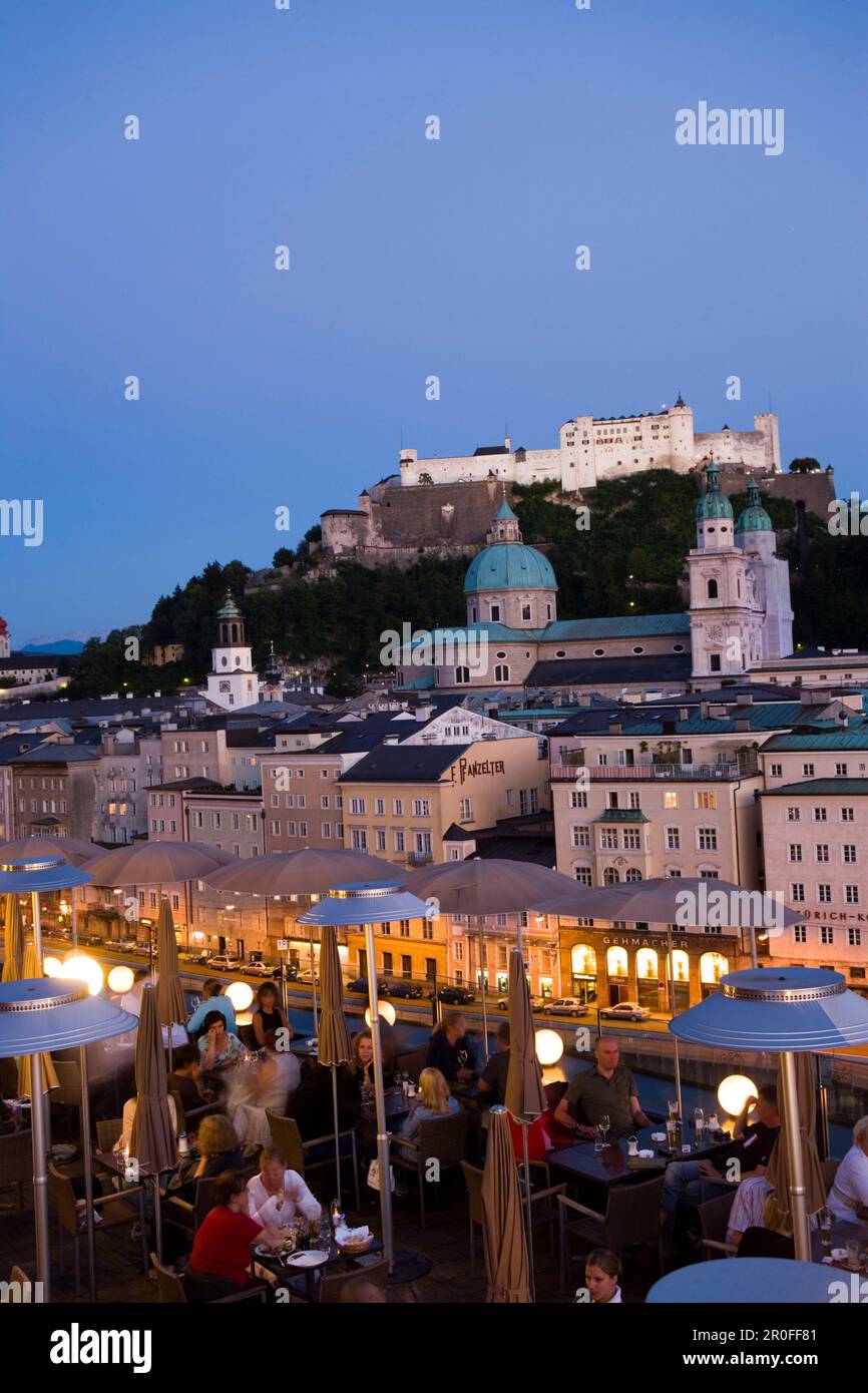 Blick über die beleuchtete Dachterrasse des Restaurants Hotel Stein in die Altstadt mit Salzburger Dom und Hohensalzburger Festung, die größte, vollständig erhaltene Festung Stockfoto