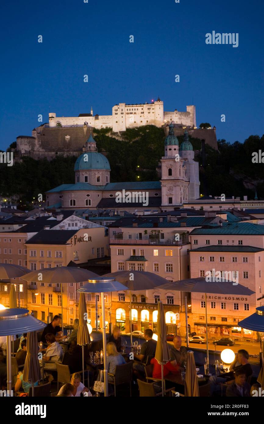 Blick über die beleuchtete Dachterrasse des Restaurants Hotel Stein in die Altstadt mit Salzburger Dom und Hohensalzburger Festung, die größte, vollständig erhaltene Festung Stockfoto