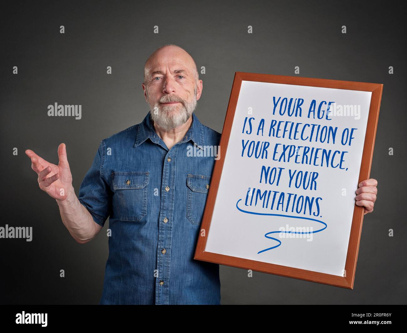 Ihr Alter spiegelt Ihre Erfahrung wider, nicht Ihre Grenzen - inspirierende Botschaft auf einem Whiteboard, die einem glücklichen und selbstbewussten Senior-Mann gehalten wird Stockfoto