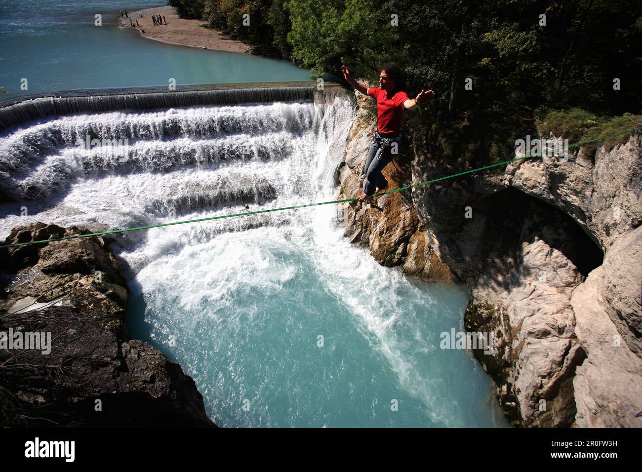 Junger Mann balanciert am Seil über einem Fluss, Füssen, Bayern, Deutschland Stockfoto
