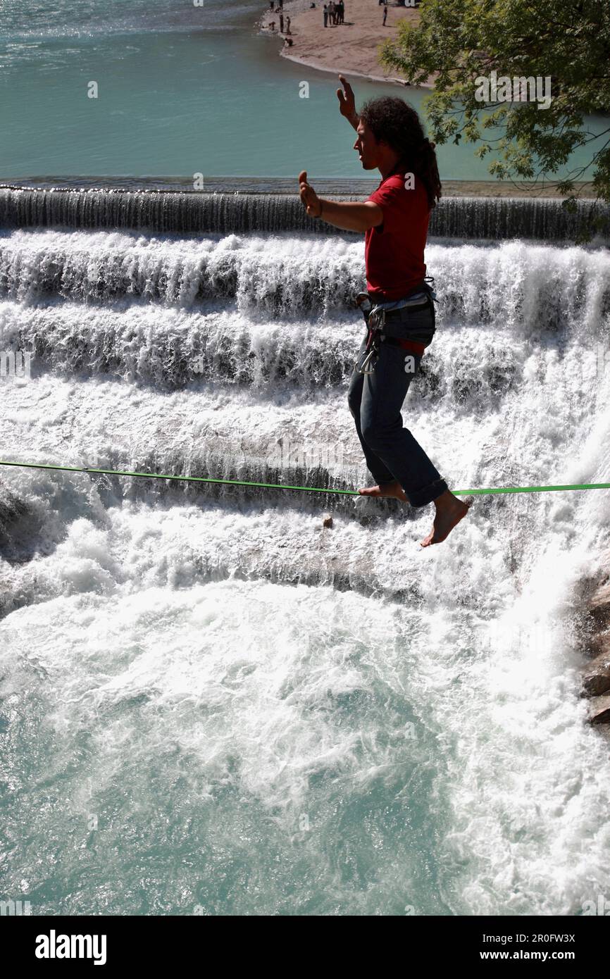 Junger Mann balanciert am Seil über einem Fluss, Füssen, Bayern, Deutschland Stockfoto