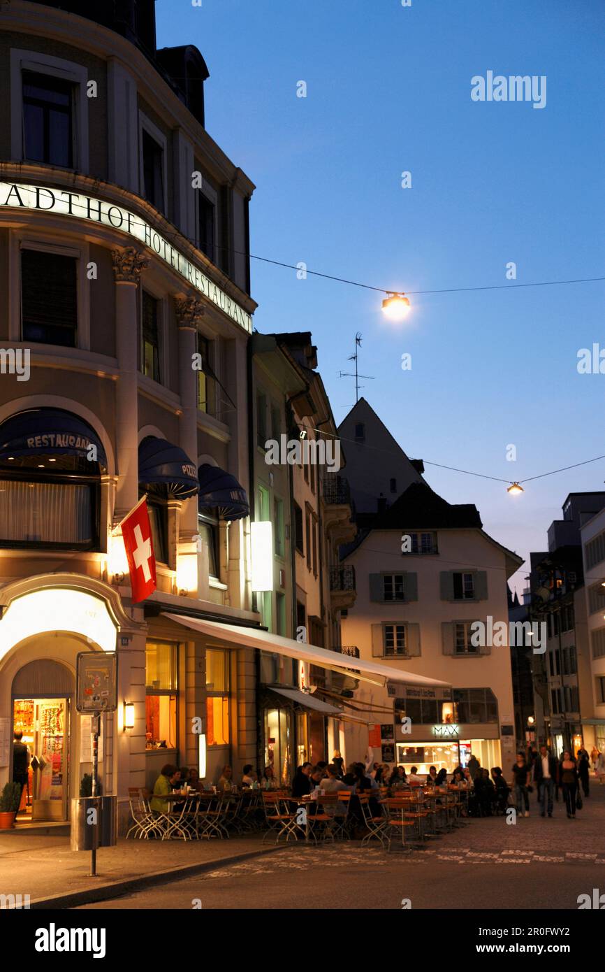 Leute sitzen in einem Café im Abendlicht, Barfuesserplatz, Gerbergasse, Basel, Schweiz Stockfoto