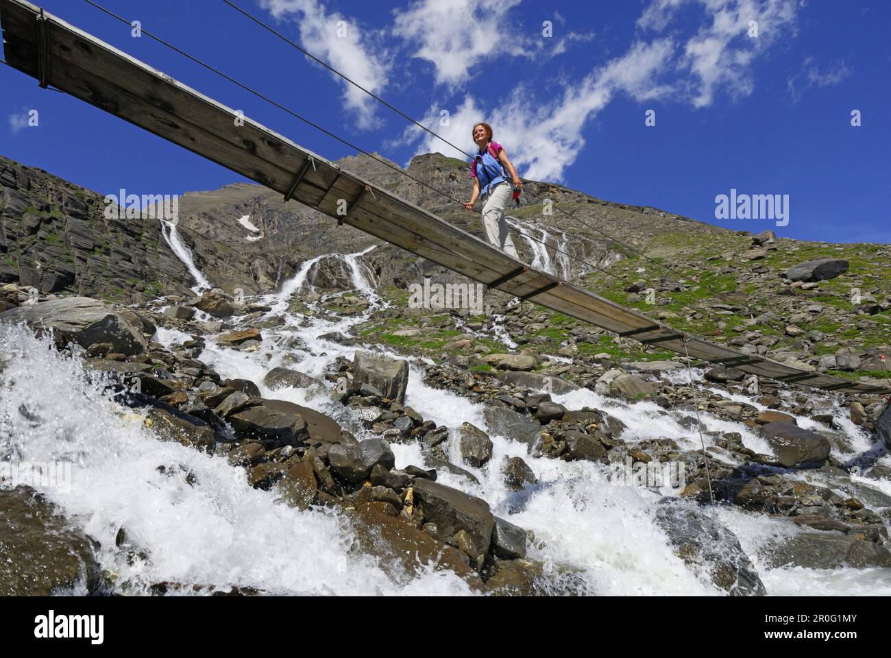 Frau auf einer Brücke, die den Fluss überquert, Nationalpark hohe Tauern, Salzburg, Österreich Stockfoto