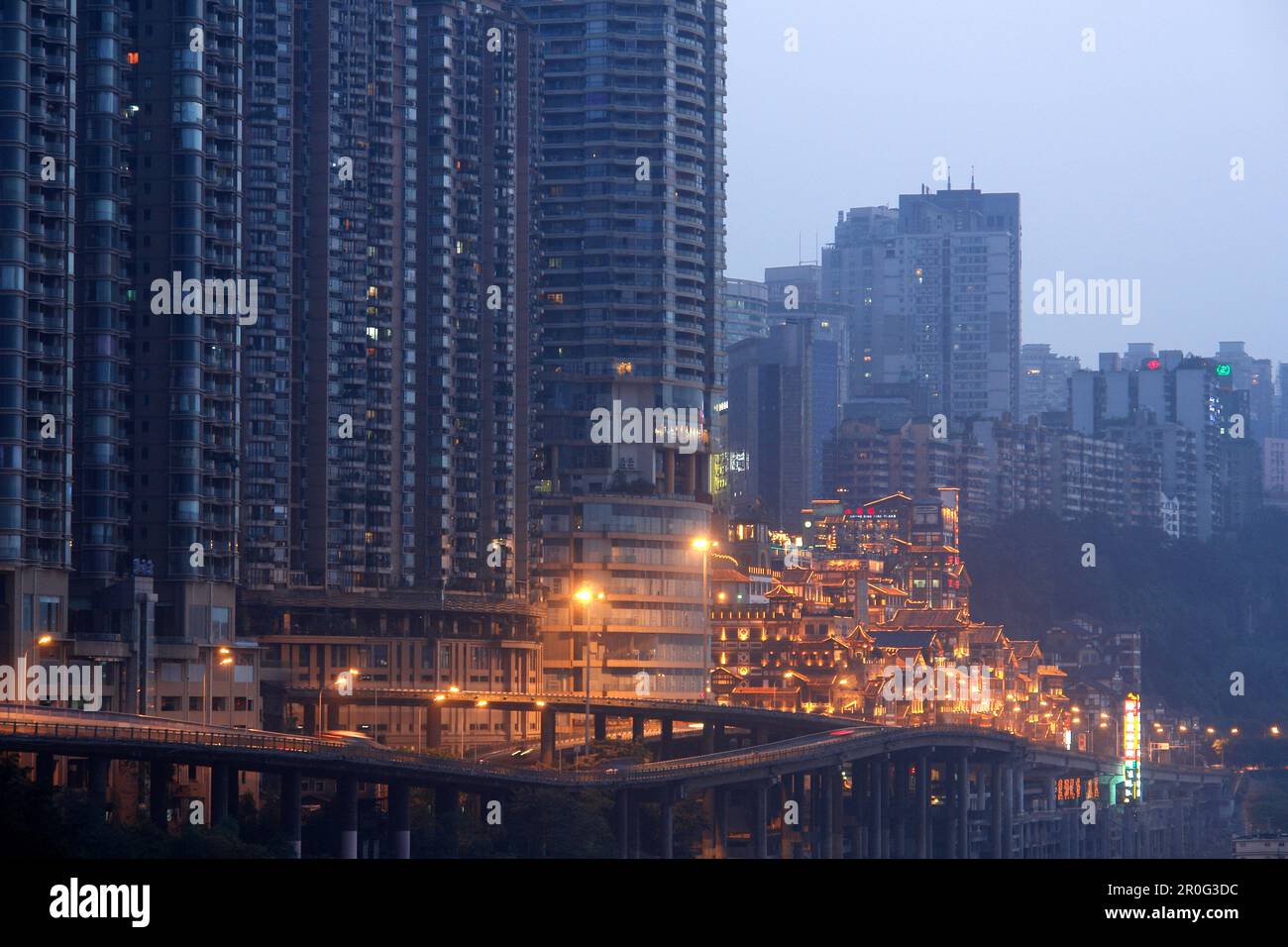 Dunkle, futuristisch aussehende Wolkenkratzer und die hoch beleuchtete Hongyadong Folklor Mall, Chongqing, China, Asien Stockfoto