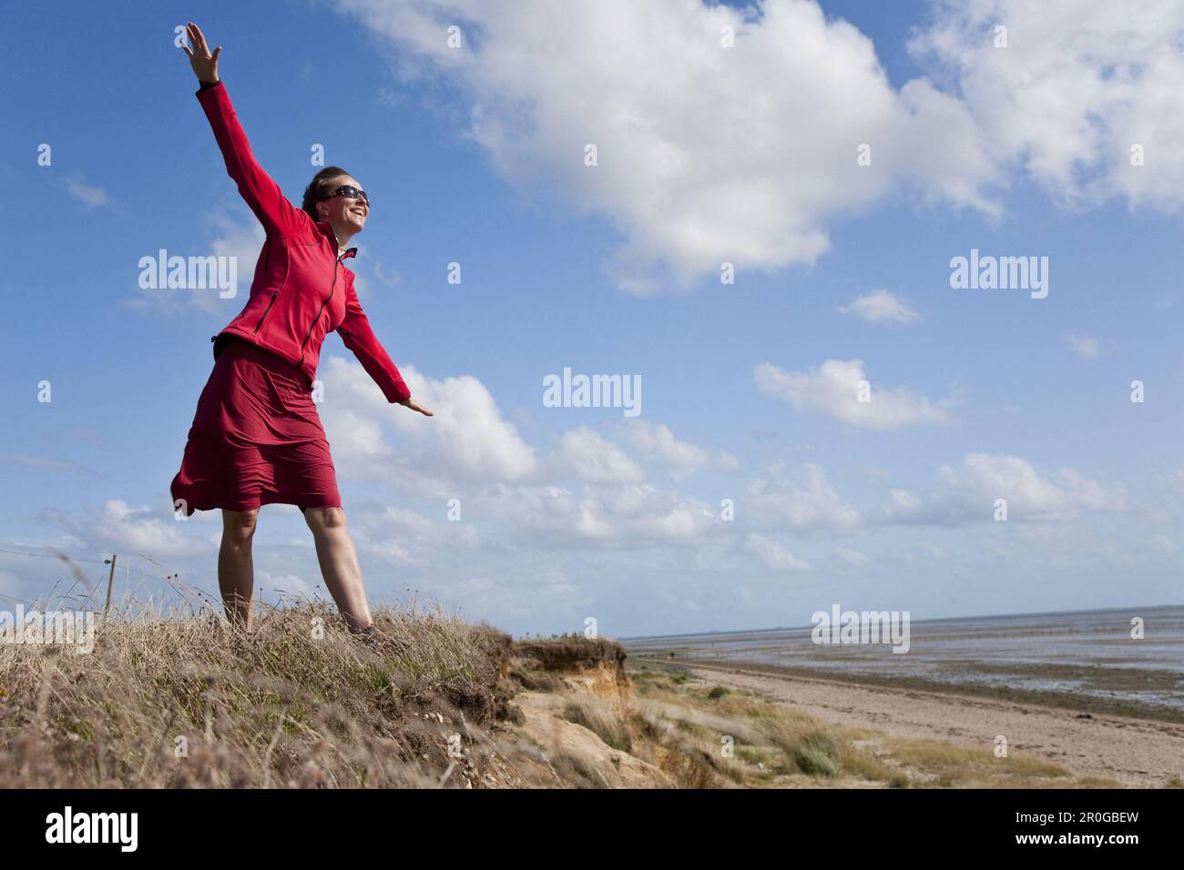 Frau mit ausgestreckten Armen am Strand von Utersum, Insel Foehr, Schleswig-Holstein, Deutschland Stockfoto