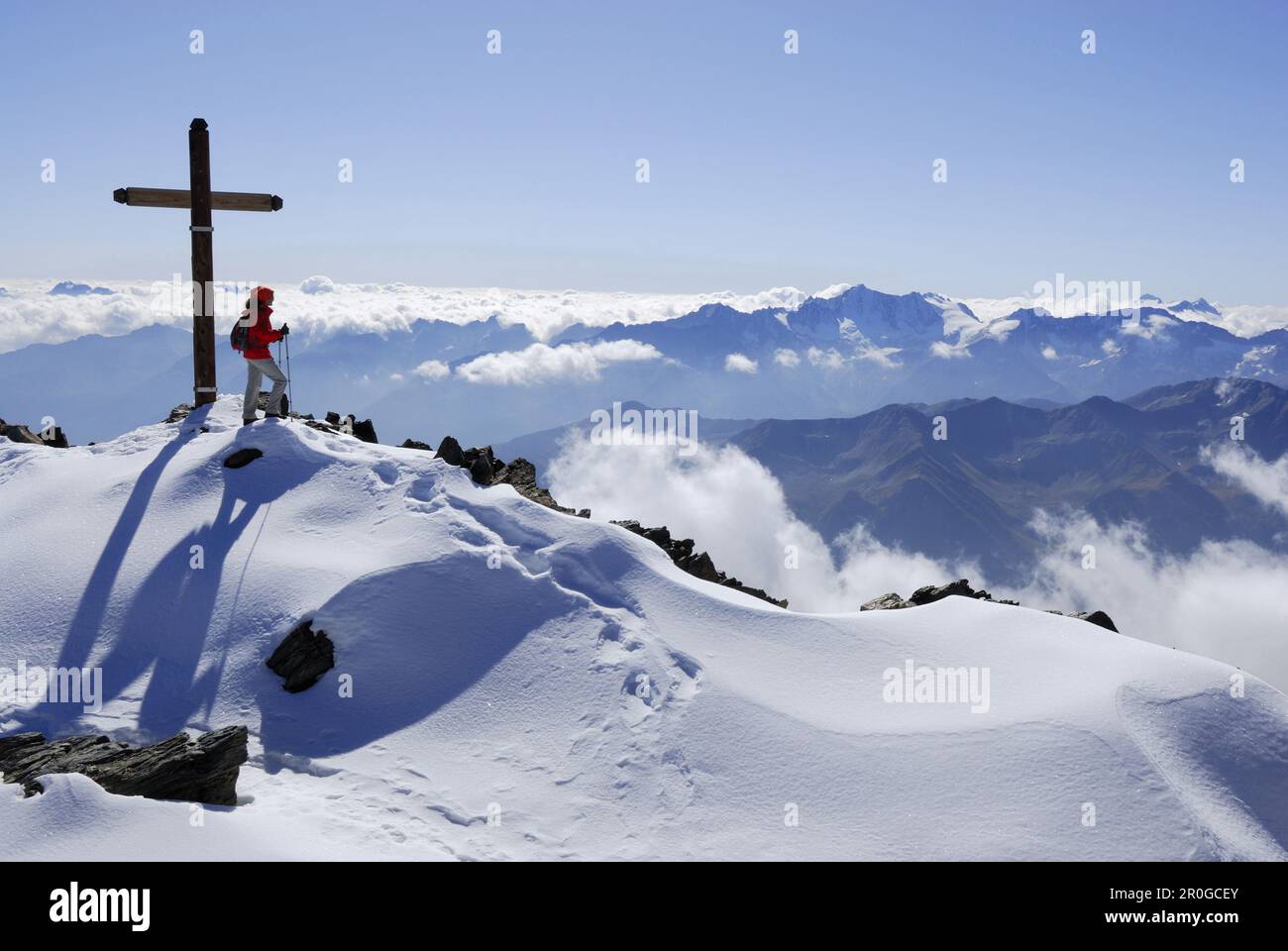 Frau am Gipfelkreuz von Monte Vioz, Ortler Range, Südtirol, Italien Stockfoto