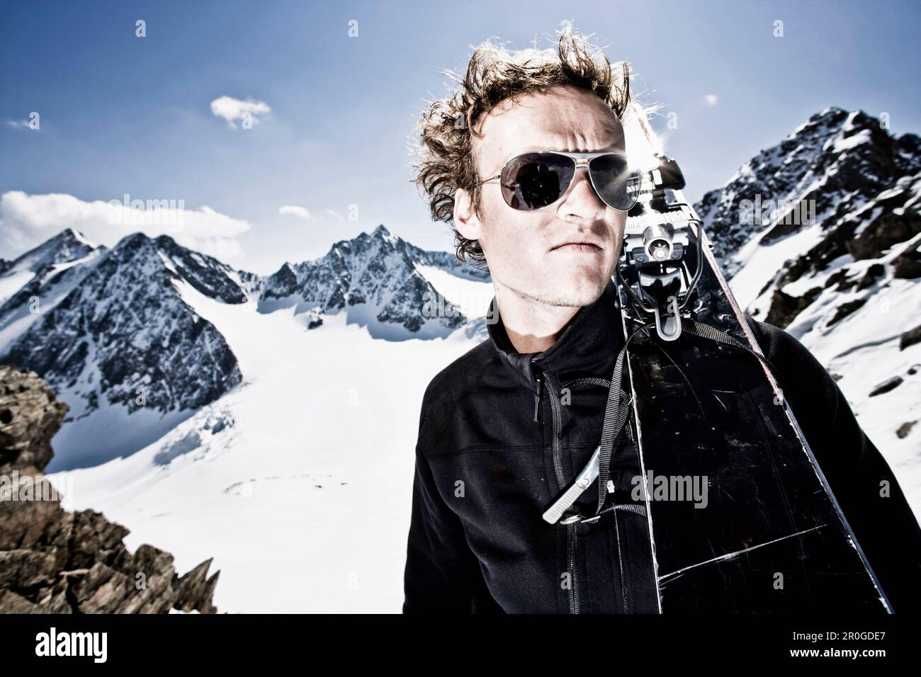 Junger Mann mit Telemark-Skiern auf der Schulter vor der östlichen Seespitze, der Westlichen Seespitze und der Ruderhofspitze, der Wildgratscharte, der Stubaier Alpen, T. Stockfoto