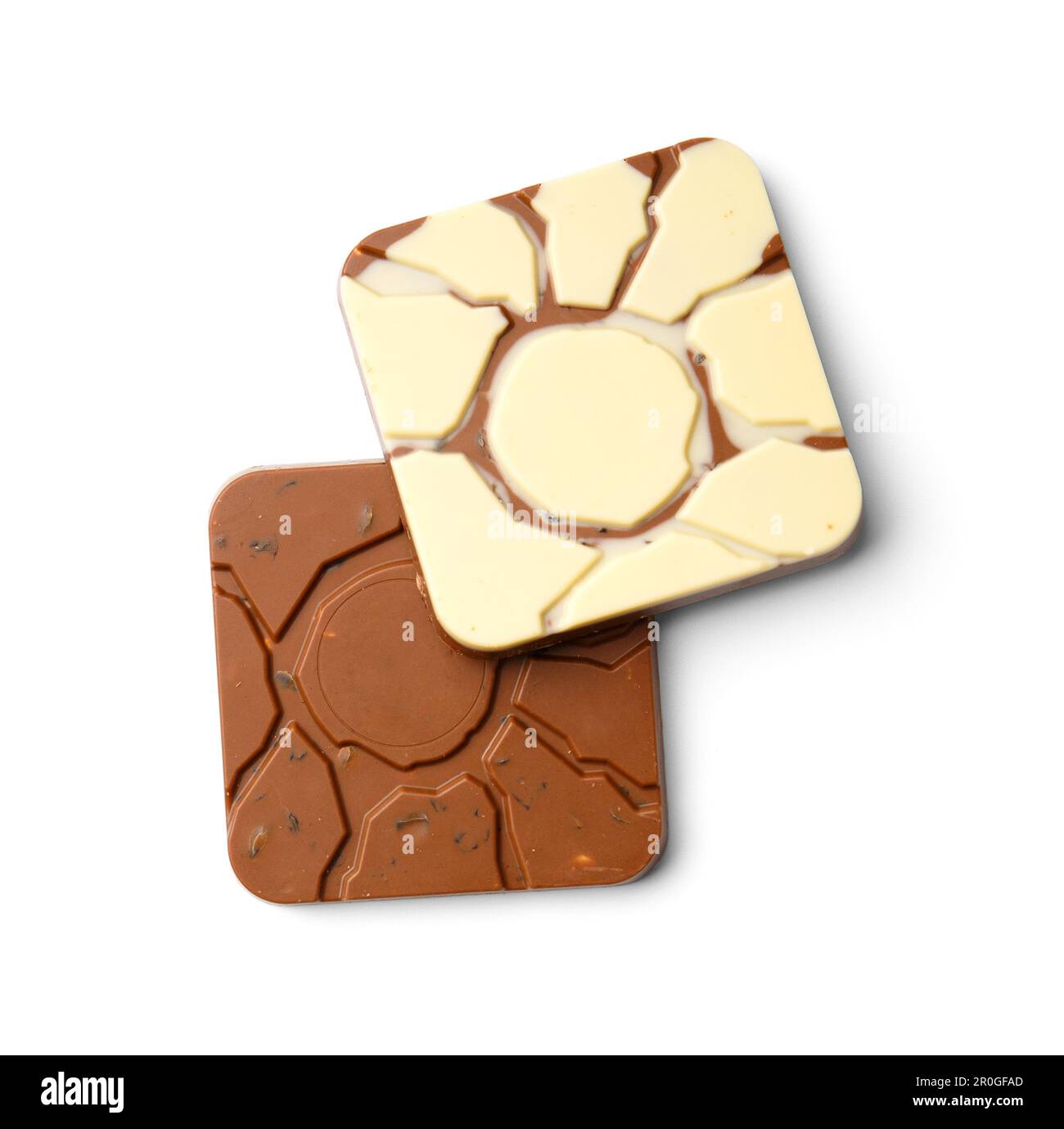 Ein Stück Weiß und ein Stück Milchschokolade übereinander auf weißem Hintergrund von oben. Zwei quadratische Schokoriegel mit Nüssen und Rosinen Stockfoto