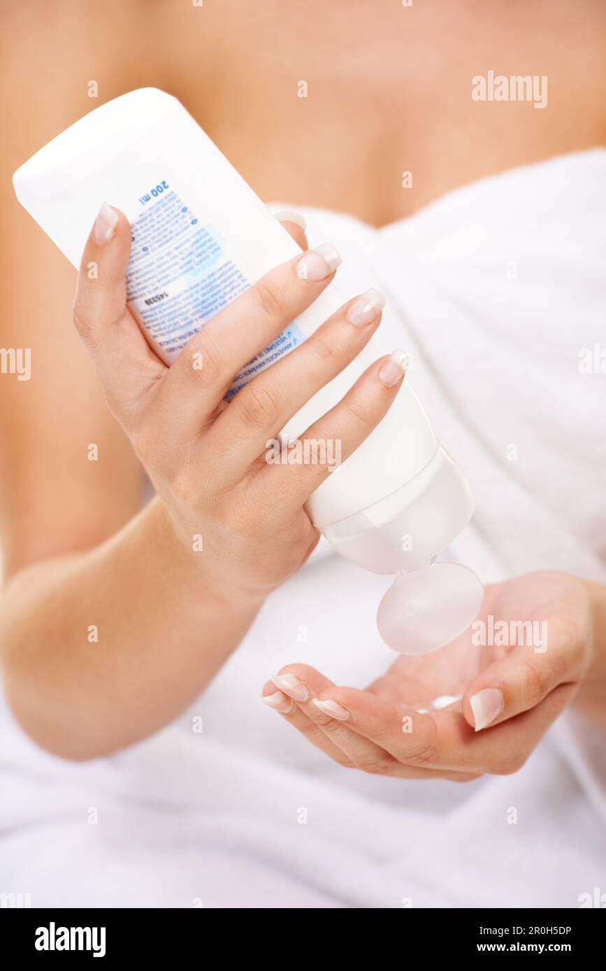 Ich achte darauf, dass meine Haut Feuchtigkeit einschließt. Eine junge Frau, die Körperlotion auf ihre Hand presst. Stockfoto