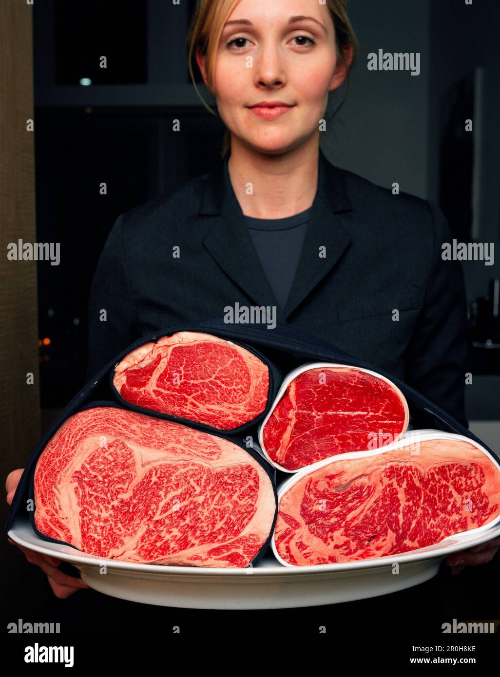 USA, Kalifornien, Los Angeles, junge Kellnerin stand halten das Fleisch Fach am Schnitt Restaurant. Stockfoto