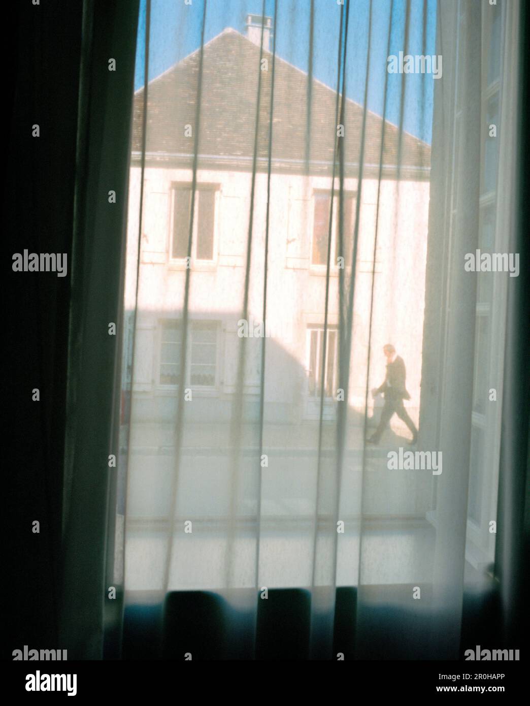 FRANKREICH, Burgund, ein Mann, der auf der Straße durch ein Fenster mit Vorhängen läuft, Chablis Stockfoto