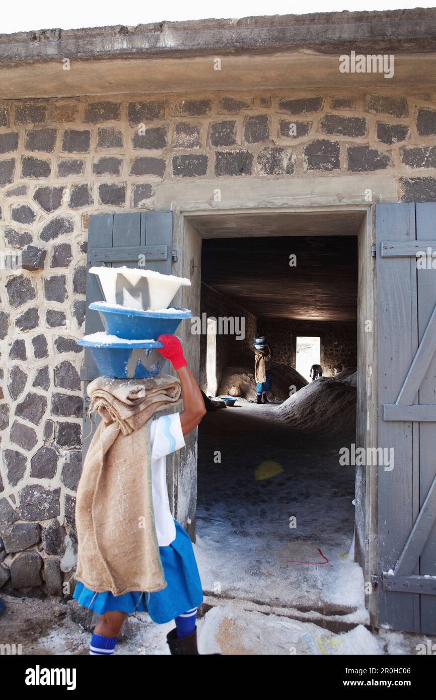 MAURITIUS, Tamarin, Frauen Tragen schwerer Lasten von Salz in einem Lager, wo sie gespeichert werden und für den Transport vorbereitet, Tamarin Salinen Stockfoto