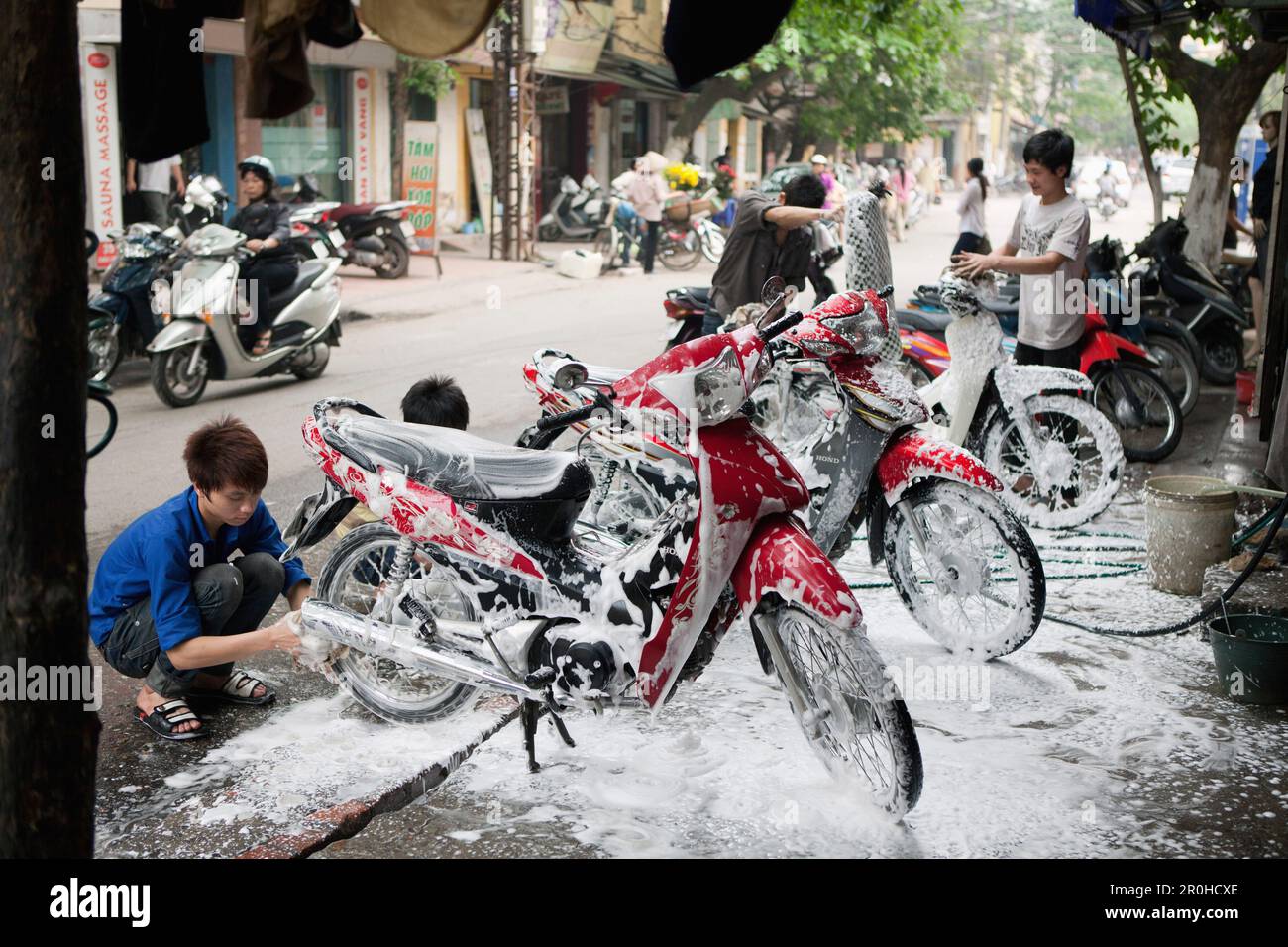 VIETNAM, Hanoi, jungen Waschen, Detail und saubere Mopeds Stockfoto