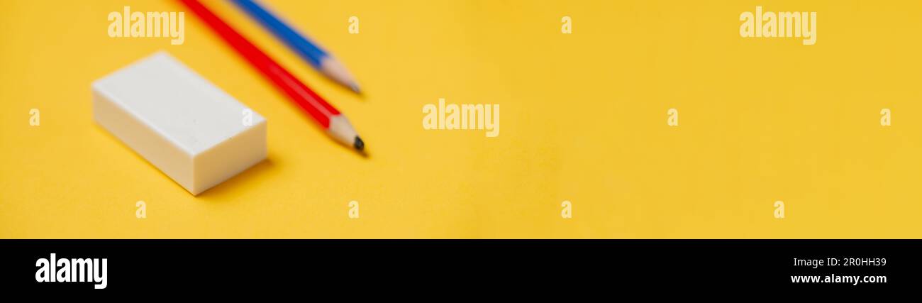 Radierer und Bleistifte auf gelbem Hintergrund. Banner, für Text platzieren. Briefpapier. Stockfoto