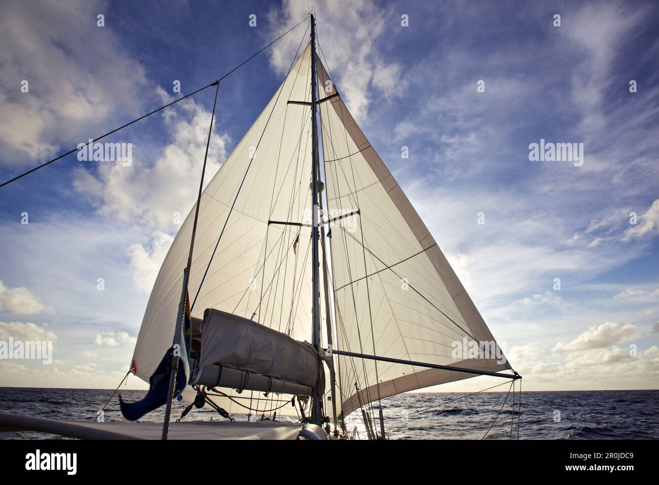 Sonnenuntergang hinter dem Segel eines Segelboots, Yacht auf dem Atlantischen Ozean, Segeln Stockfoto
