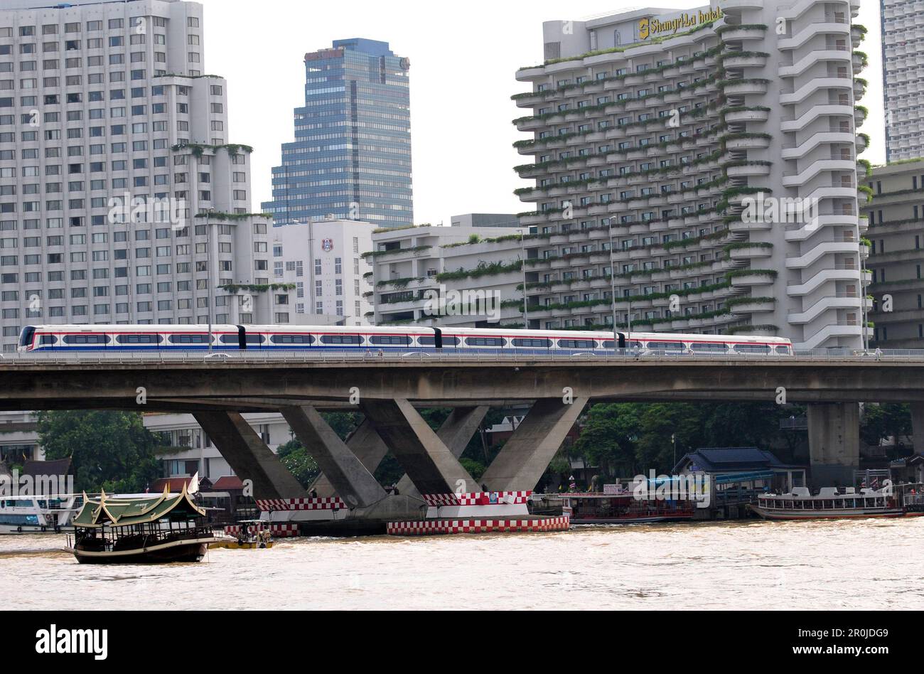 Ein BTS Skytrain über die Taksin Brücke über den Chao Phraya River in Bangkok, Thailand. Stockfoto