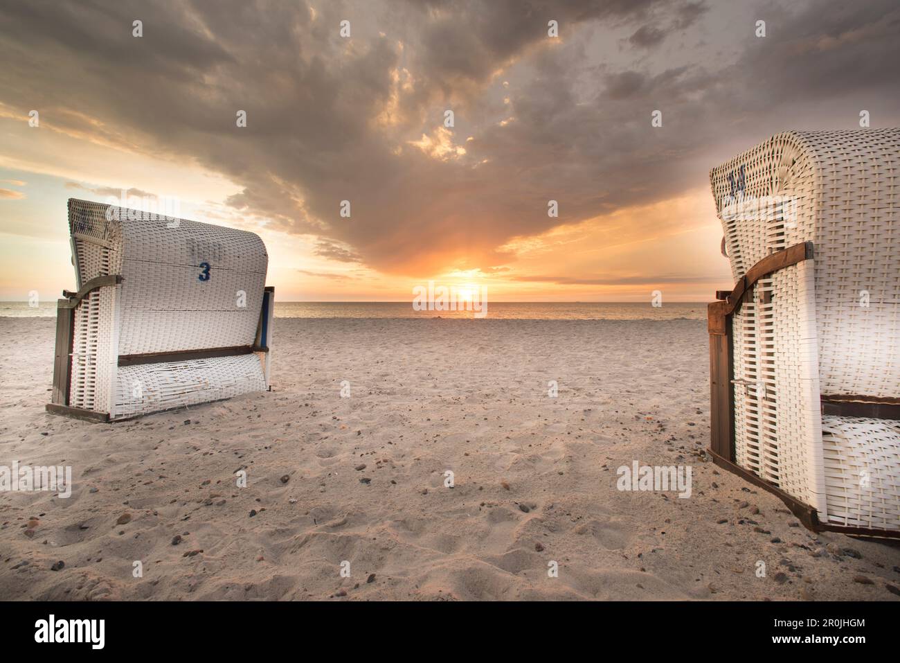 Strandliegen am Strand in Dierhagen vor einem bewölkten Himmel und Sonnenuntergang, Nationalpark Lagunenregion Westpommern, Dierhagen, Mecklenburg Vorpom Stockfoto