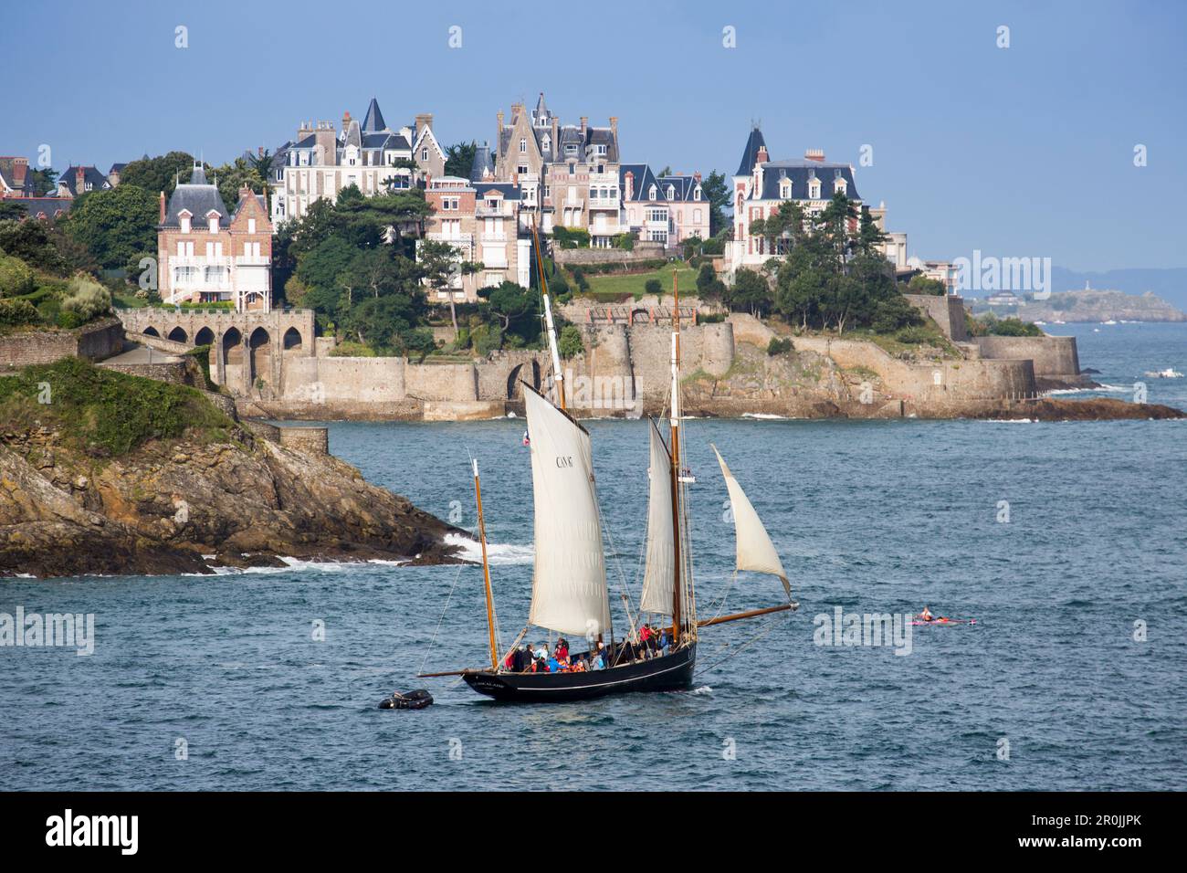 Ausflug Segelboot La Cancalaise (Nachbildung des 1905 französischen Cutters Le Perle) während des Segelausflugs in der Bucht von Saint-Malo mit Dinard-Küste dahinter, DIN Stockfoto