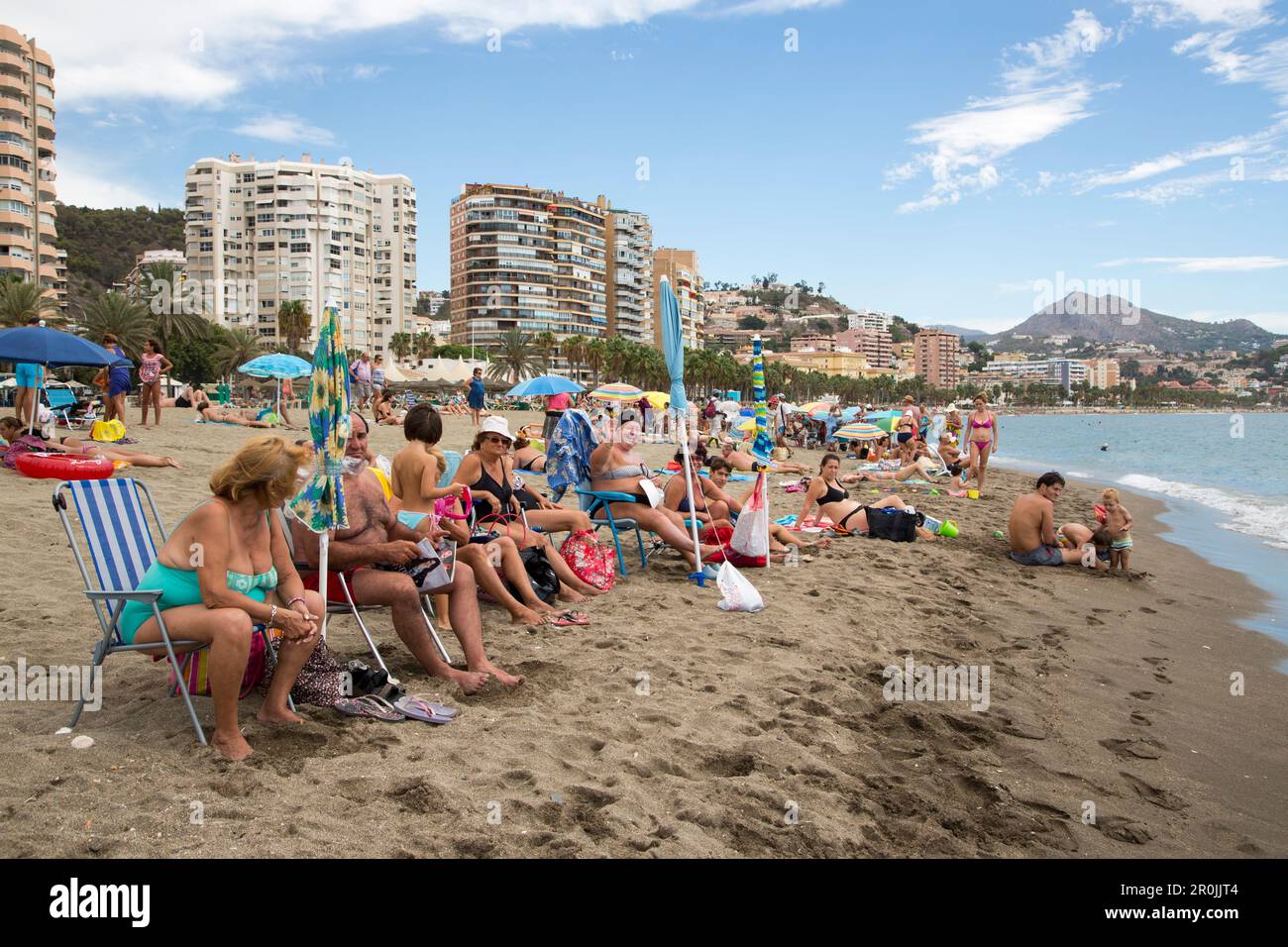 Rentner am Strand Playa de la Malagueta mit Hochhäusern, Malaga, Costa del Sol, Andalusien, Spanien Stockfoto