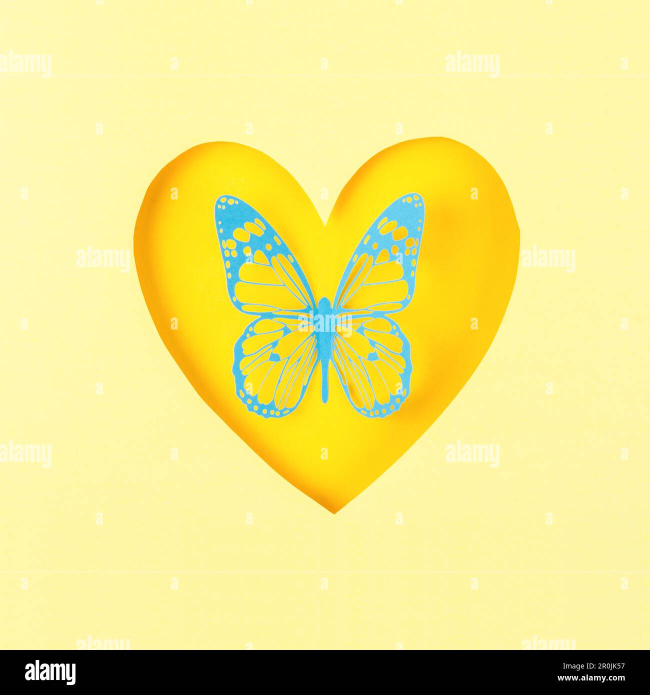 Schmetterling aus Schnitzpapier oder herzförmigem Papier auf gelbem Hintergrund. Stockfoto