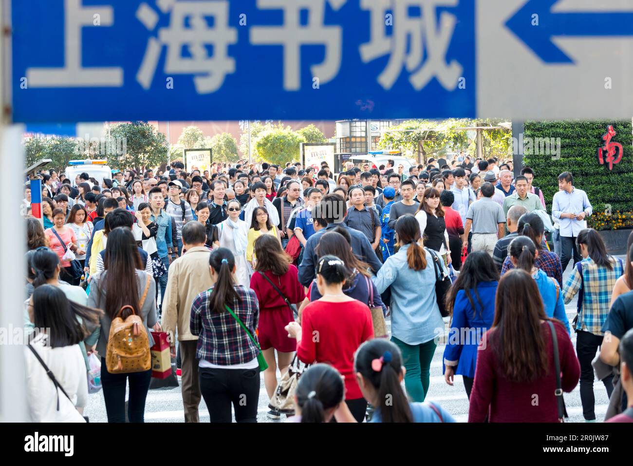 Viele Chinesen überqueren eine Kreuzung, Kreuzung, chinesischer Charakter Shanghai Buchladen, Massen von Menschen, Gesichter, Porträts, Nanjing Lu, Nanjing Straße, sh Stockfoto