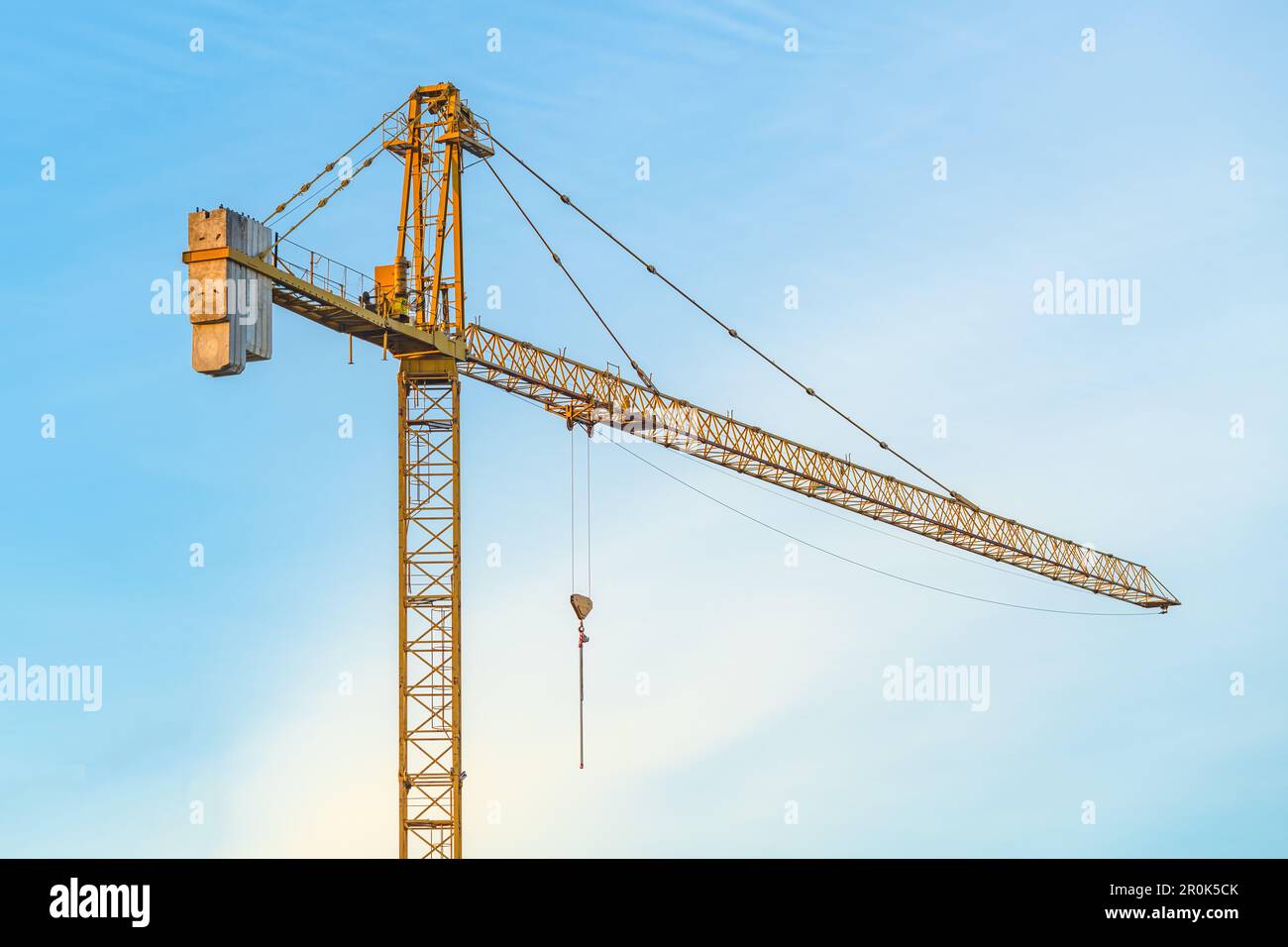 Gelbe industrielle Baukranmaschinen vor Ort vor blauem Himmel Stockfoto