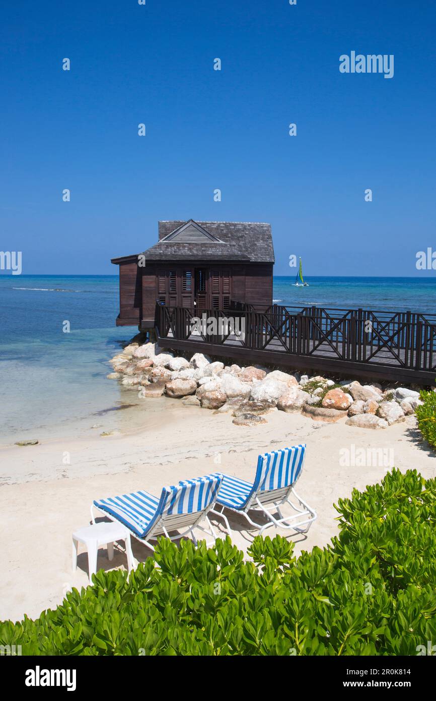 Strandliegen und Spa Cabana über dem Wasser im Half Moon Resort Rose Hall, in der Nähe von Montego Bay, Saint James, Jamaika Stockfoto