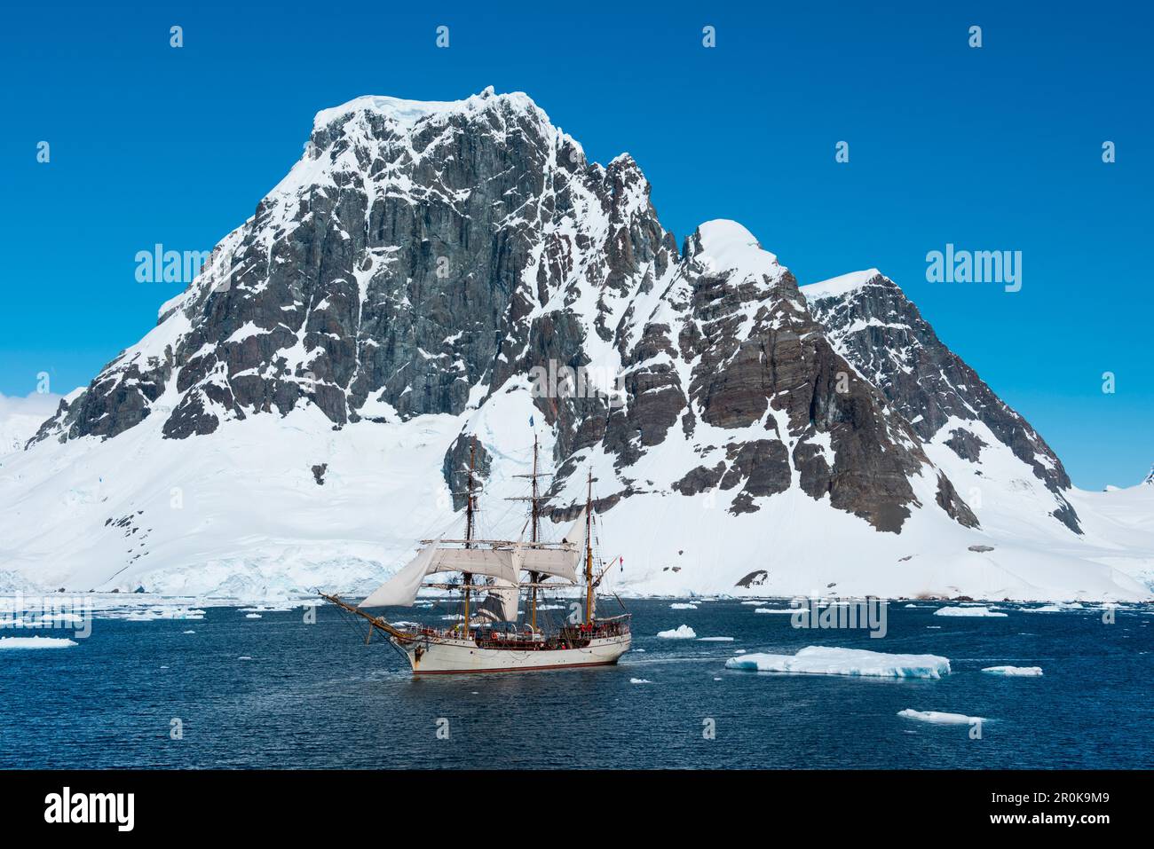 Segeln Rinde Europa inmitten von Eisschollen mit Bergen dahinter Stockfoto