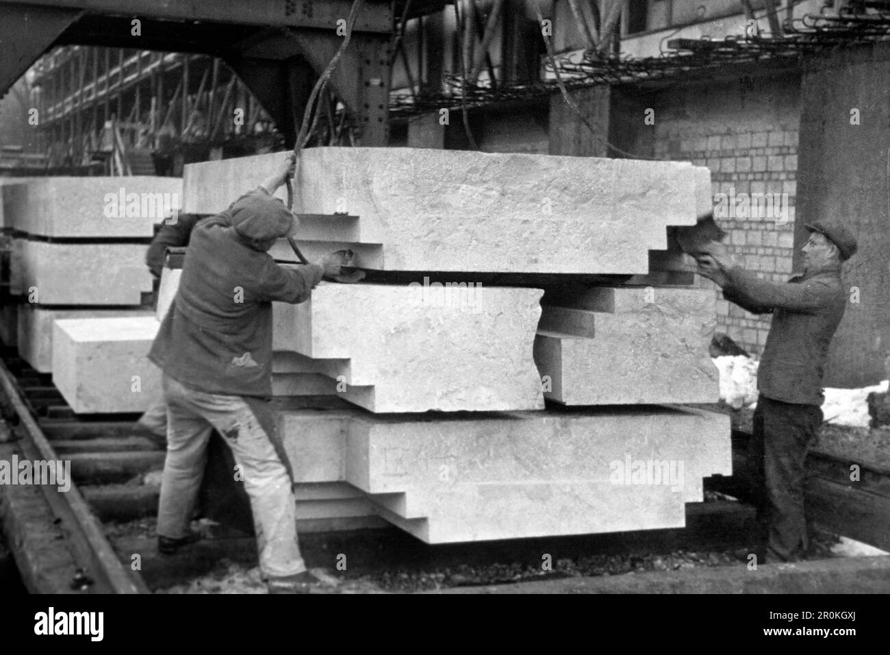 Bauarbeiter bewegen Granitblöcke auf der Baustelle des Hauses der Deutschen Kunst, heutzutage Haus der Kunst, München 1936. Bauarbeiter, die Granitblöcke auf der Baustelle des Hauses der Deutschen Kunst, jetzt Haus der Kunst, München 1936, bewegen. Stockfoto